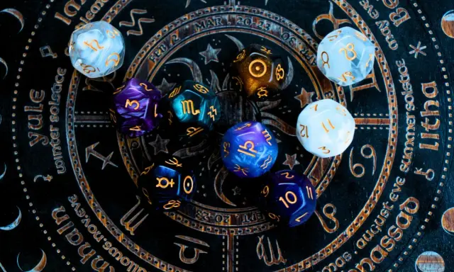 Kolorowe kości do gry na tle zodiaku. Czy to zapowiedź horoskopu tygodniowego dla Wagi?