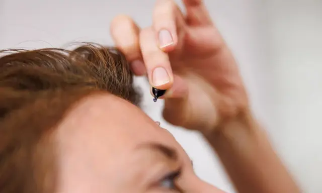 Dłoń trzyma kapsułkę z serum. To celimax retinal shot, który zaraz zostanie zaaplikowany na skórę.