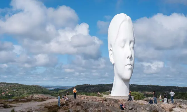Enormt vitt ansikte reser sig mot en molnig himmel. En av de mest minnesvärda platserna att besöka i Göteborg.