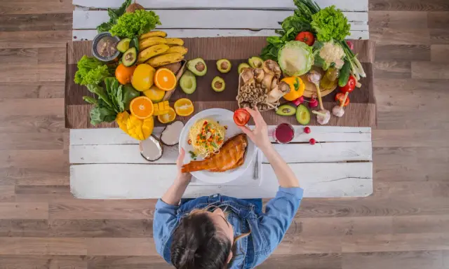 Zdrowa dieta w chorobie nerek: ryba, makaron, warzywa i owoce na stole.