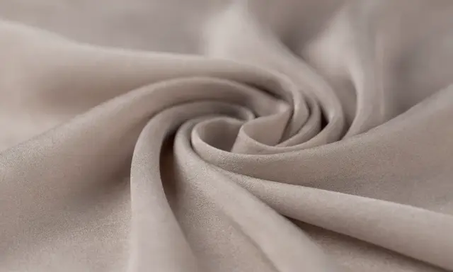 A swirl of soft, beige fabric. This close-up shows the texture and drape of a material, making one wonder, is viscose a good material for flowy garments?