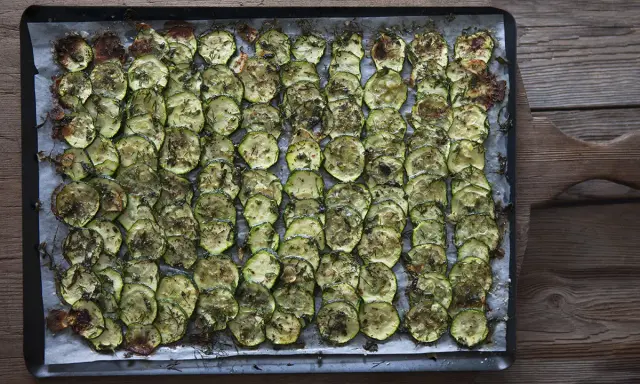 En plåt med ugnsbakad zucchini, skivad och kryddad med örter. Perfekt som tillbehör till middagen.