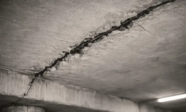Detalle de grietas en el techo de hormigón, mostrando el acero de refuerzo expuesto. Posibles causas de grietas en el techo.