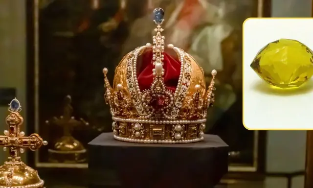 Korona ozdobiona perłami i klejnotami, obok krzyż. W rogu żółty kamień, być może diamenty tekst.