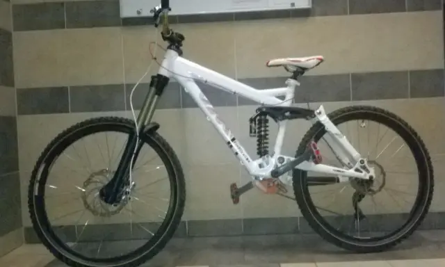 Biały rower zjazdowy z pełnym zawieszeniem i napędem 2x9, gotowy na trudne trasy.