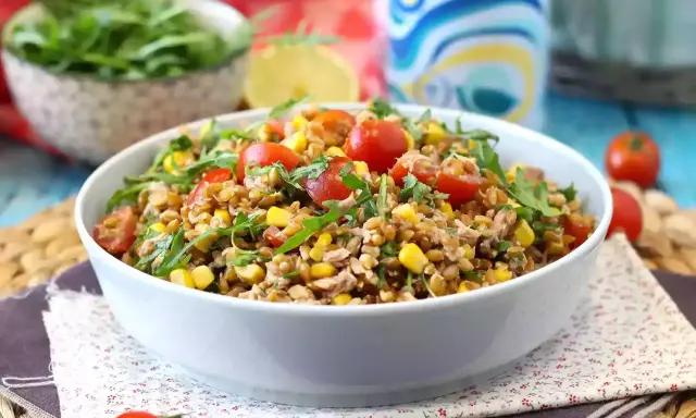 Una gustosa insalata di farro estiva con pomodorini, mais e rucola, perfetta per un pasto leggero e nutriente.
