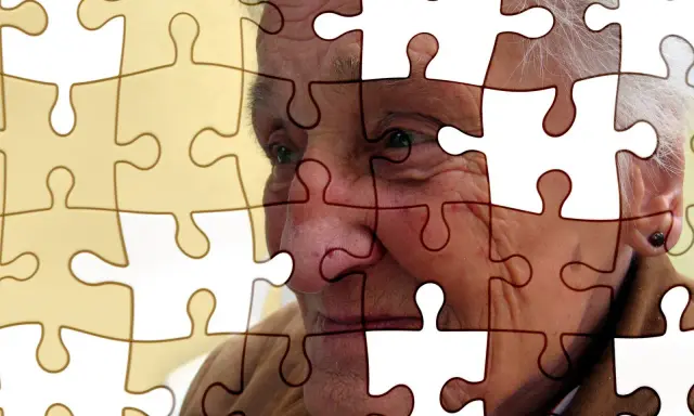 Twarz starszej osoby z Alzheimerem, jak puzzle, które powoli się rozpadają. Jak poznać, że chory na alzheimera umiera?