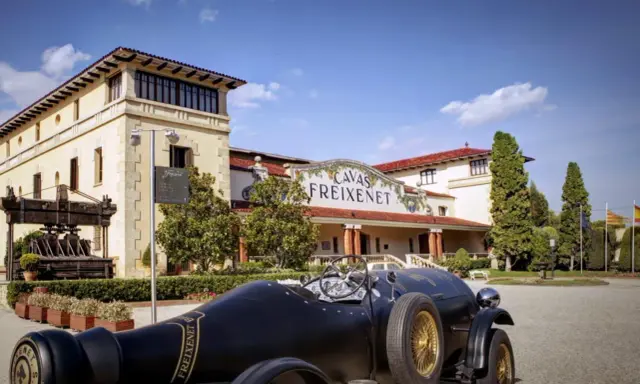 Un coche clásico negro frente a las Cavas Freixenet en Penedès.