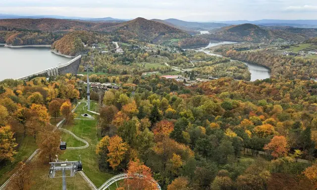 Jesienna panorama z widokiem na zaporę w Solinie i kolejkę gondolową. W oddali jezioro i góry.