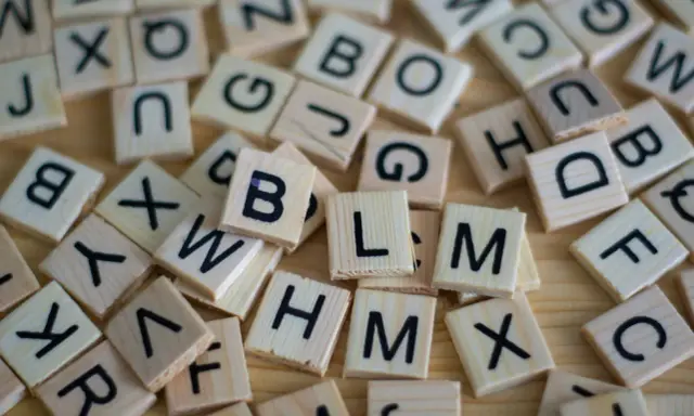 Drewniane klocki z literami, jak w grze Scrabble. Układają się w słowa, może nawet w najdłuższe słowo po angielsku?