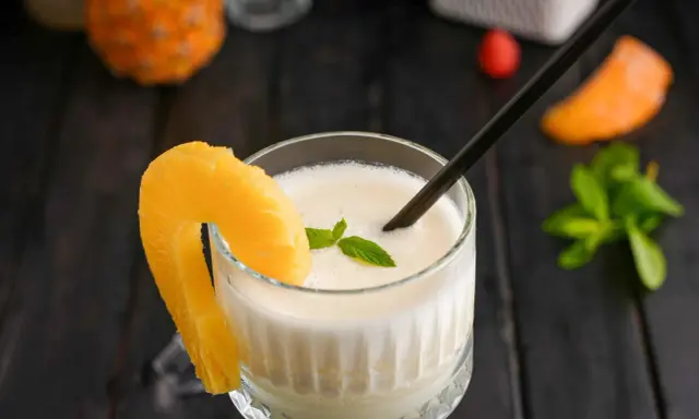 En krämig pina colada med ananasskiva och mynta, redo att avnjutas.