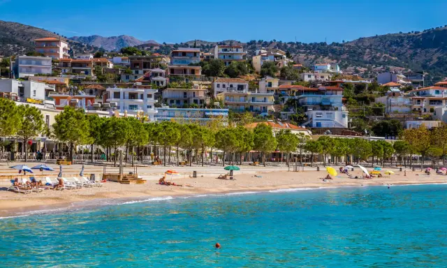 Albania, wrzesień, pogoda idealna na plażowanie. Słoneczny dzień, turkusowe morze i miasteczko na wzgórzu.