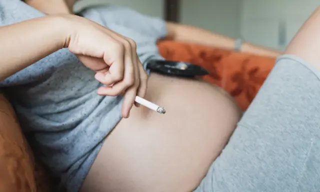 Schwangere Frau hält Zigarette. Hilfe beim Rauchstopp: Cytisin rezeptfrei.