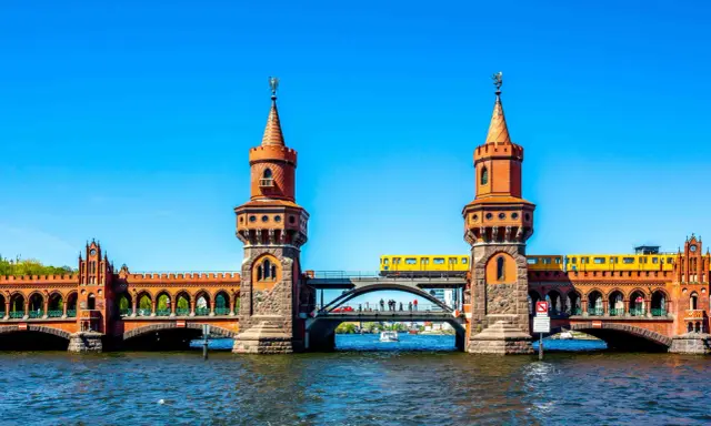 Oberbaumbrücke in Berlin: Ein Muss für jeden Besucher. Eine gelbe U-Bahn fährt über die historische Brücke, die mit ihren Türmchen und Bögen beeindruckt.