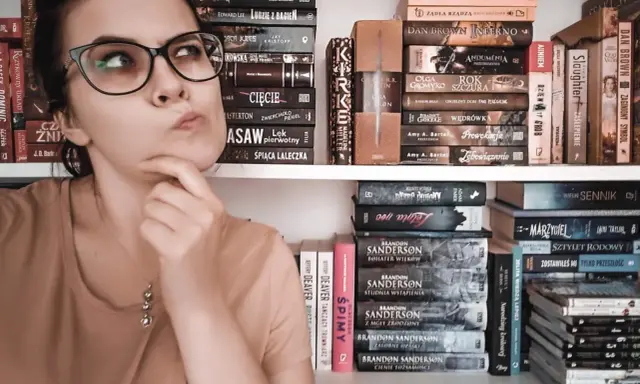 Dziewczyna z okularami zastanawia się nad wyborem książki. Na półkach obok kryminały, fantasy i erotyka subtelna.