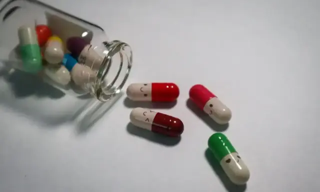 Kapsułki z uśmiechniętymi buźkami, niektóre wypadły z buteleczki. Leki antydepresyjne a wyniki krwi - czy mają wpływ na samopoczucie?