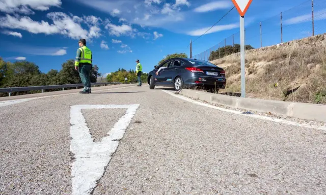Agentes de tráfico controlan la circulación en una carretera. Un coche se detiene, quizás preguntándose cuánto tarda en llegar una multa.
