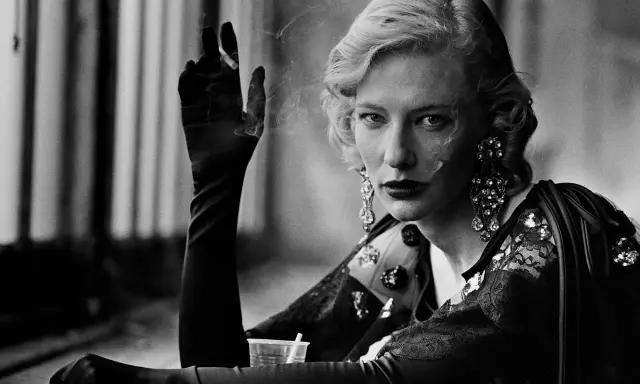 A woman with blonde hair and dramatic earrings smokes, a signature element in many Peter Lindbergh famous photos.