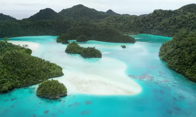 Rajskie krajobrazy Raja Ampat: turkusowe laguny, piaszczyste ławice i bujna zieleń tropikalnych wysp.