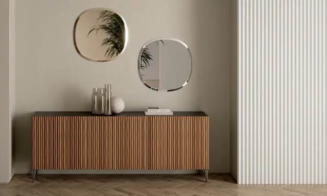 Come arredare una madia moderna: due specchi ovali e vasi decorativi creano un punto focale elegante.