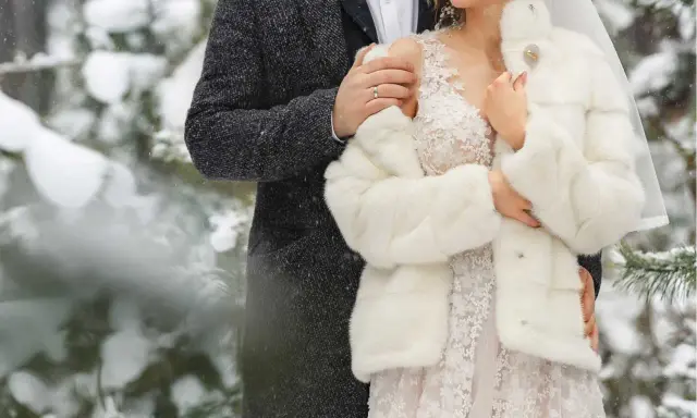 Para młoda w objęciach, otulona śniegiem i miłością. Romantyczne zimowe wesele w lesie.