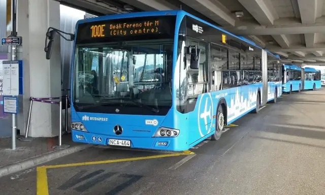 Blå buss 100E vid Budapest flygplats, redo att ta passagerare till centrum.