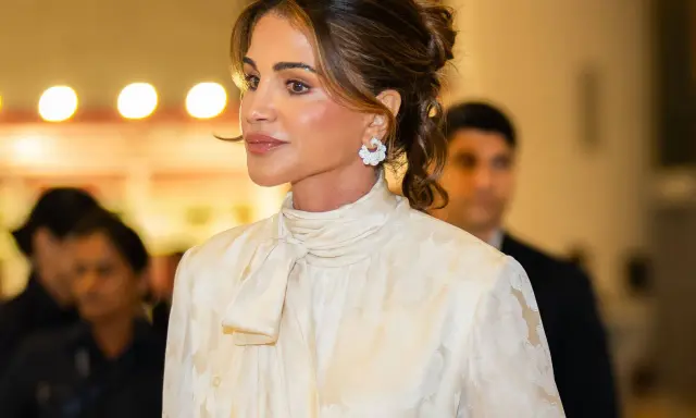Queen Rania's elegant style shines in a cream, floral-patterned blouse with a chic pussy-bow.