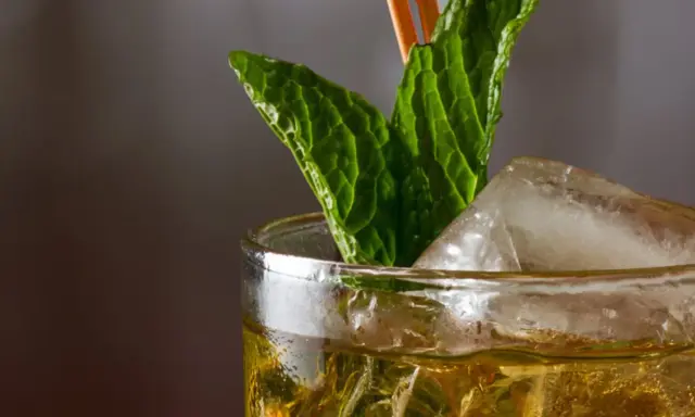 Ein erfrischender Mint Julep mit Eis und Minzblättern, bereit zum Genießen.