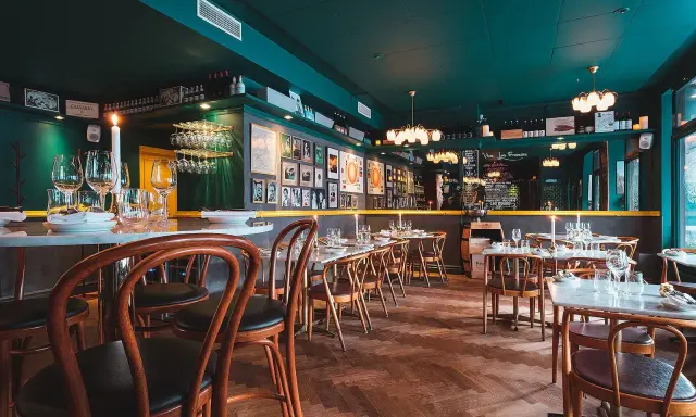Mysig sydamerikansk restaurang i Stockholm med mörkt gröna väggar, trägolv och dukade bord.