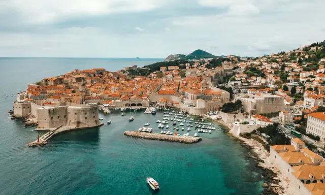 Aerial view of Dubrovnik's historic walled city and harbor, a beautiful destination for a gay vacation.