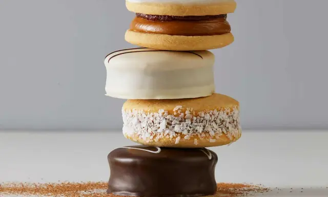 Una pila de alfajores, dulces típicos de Argentina y Uruguay, cubiertos de chocolate, coco y glaseado.
