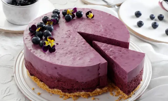 Ein wunderschöner Kuchen zum Muttertag, dekoriert mit frischen Blaubeeren und Veilchen.
