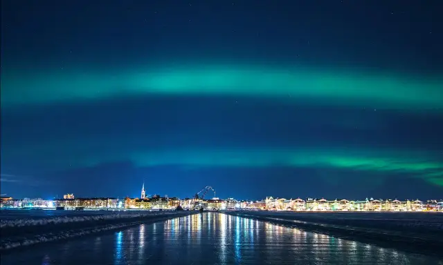 Norrsken över Luleå. En stad i ljus och en himmel målad i grönt.
