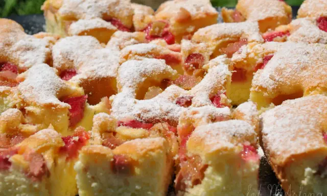 Pyszne ciasto z rabarbarem, pokrojone na kwadraty i posypane cukrem pudrem. Idealne na letnie popołudnie.