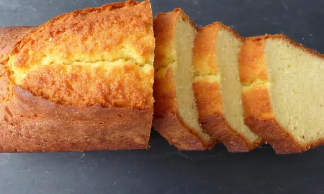 Un quatre-quarts breton, doré et moelleux, coupé en tranches sur fond sombre. Parfait pour une recette simple et gourmande.