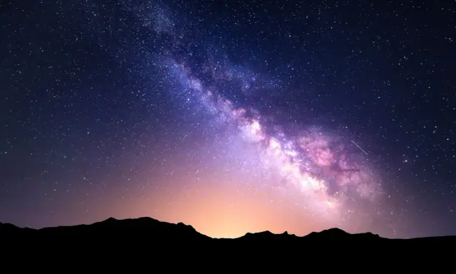 Droga Mleczna rozświetla nocne niebo nad Górami Stołowymi, tworząc magiczny widok w izerskim parku ciemnego nieba.