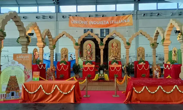 Allestimento per il festival dell'oriente Rimini con statue induiste, archi in legno e un grande striscione "Unione Induista Italiana".