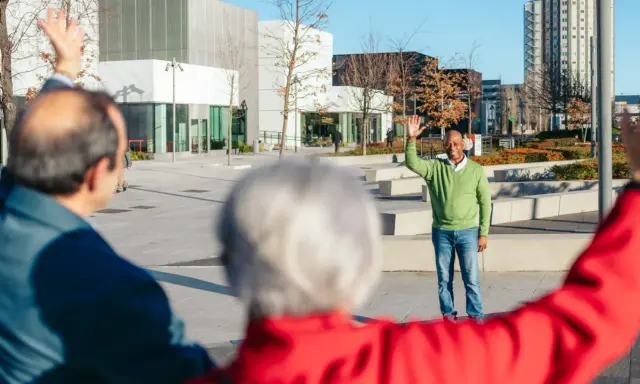 Trzech seniorów wita się na placu. To inspiracja, jak założyć klub seniora i budować społeczność.