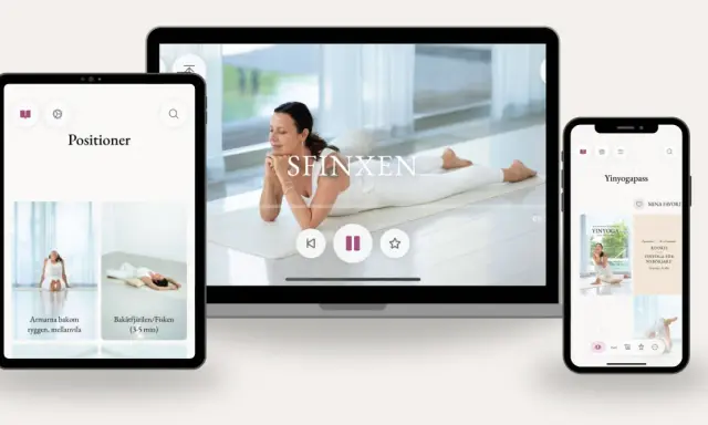 En kvinna utför morgon yoga på en matta. Skärmar visar yogaövningar och pass.