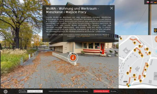 Jesienne liście na chodniku przed osiedlem WuWA we Wrocławiu. W tle budynek i drzewa. Mapa pokazuje rozmieszczenie budynków.