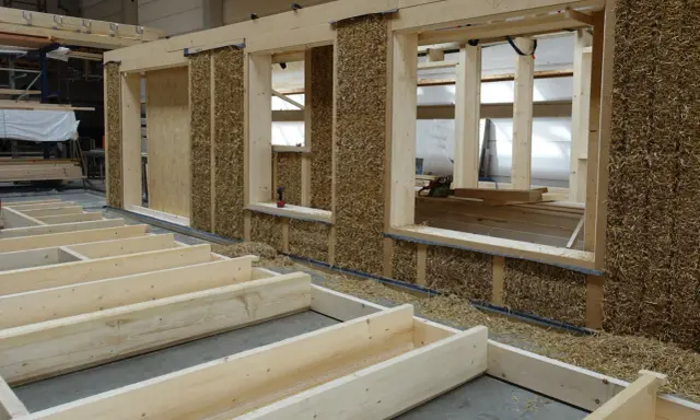 Holzkonstruktion mit Strohballenwänden im Bau. Die natürlichen holz eigenschaften machen es zu einem idealen Baustoff für nachhaltige Häuser.
