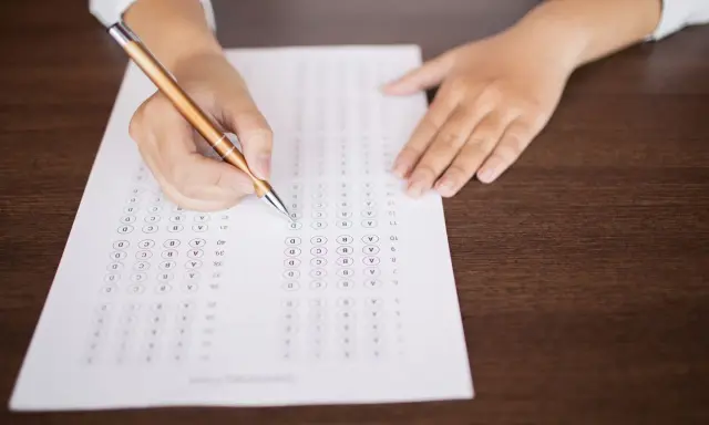 Persona completando un examen de opción múltiple, preparándose para el teórico carnet C.