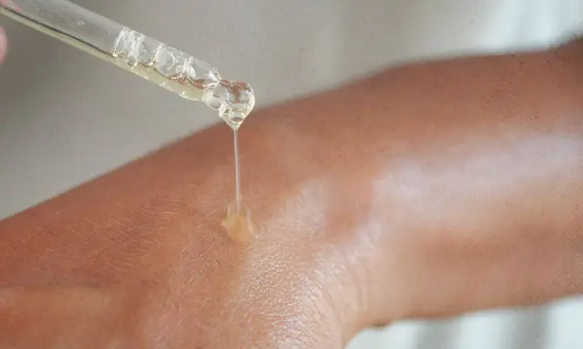 Kropla serum z niacynamidem 5% spada na skórę, nawilżając ją i odżywiając.