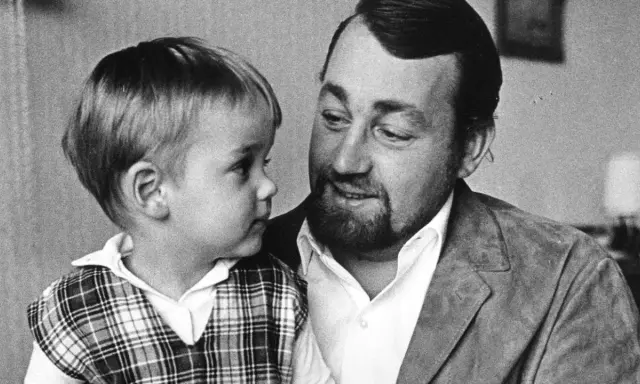 Cornelis Vreeswijk med sitt barn i en rutig väst. En varm stund mellan far och son.