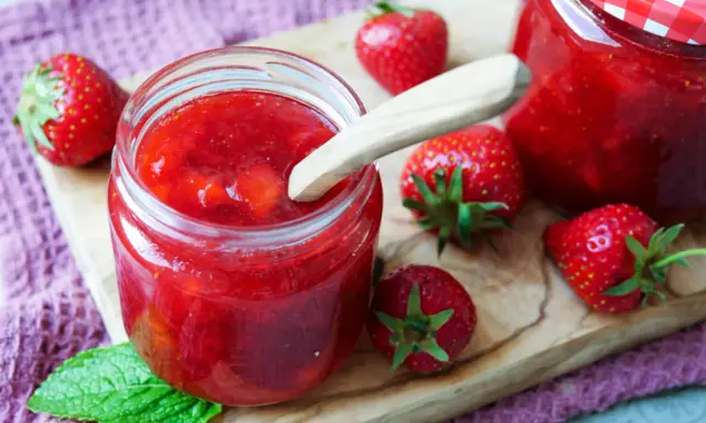 Frische Erdbeeren und selbstgemachte Marmelade in einem Glas. Perfekt zum Marmelade einfrieren für den Winter.