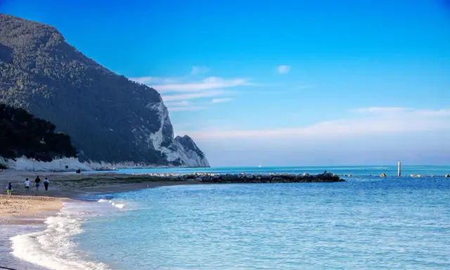 Spiaggia con scogliere e mare azzurro, ideale per scoprire dove andare al mare nelle Marche.