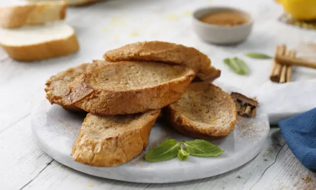 Torrijas al horno doradas y crujientes, espolvoreadas con canela, listas para disfrutar.