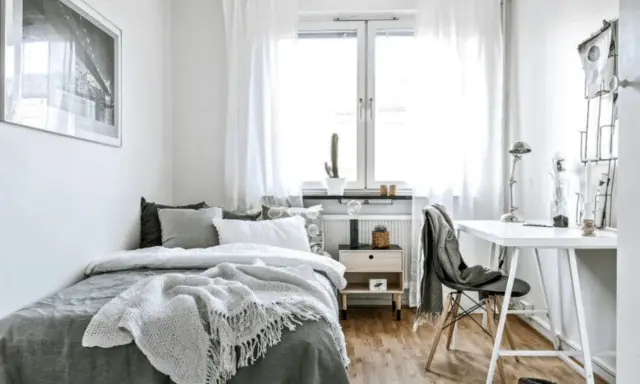 Chambre 10m2 lumineuse avec lit confortable, bureau et fenêtre. Un cactus sur le rebord de fenêtre ajoute une touche de verdure.