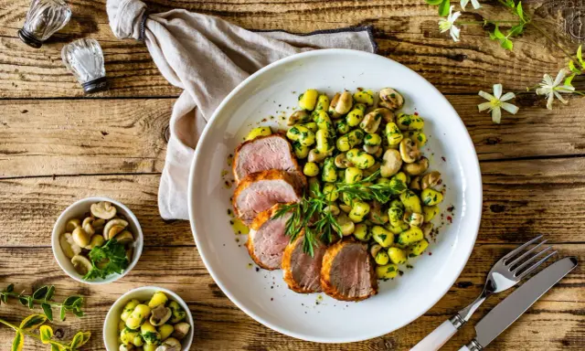 Saftige schweinelende grillen, serviert mit Kartoffeln und Pilzen, garniert mit frischer Petersilie. Ein Genuss für jeden Grillmeister!