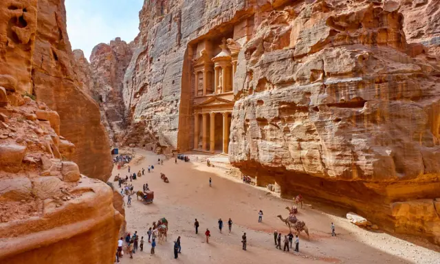 Skaliste wąwozy Petry, Jordania. Wspaniałe widoki, idealne na jordania loty. Turyści i wielbłądy w drodze do Skarbca.